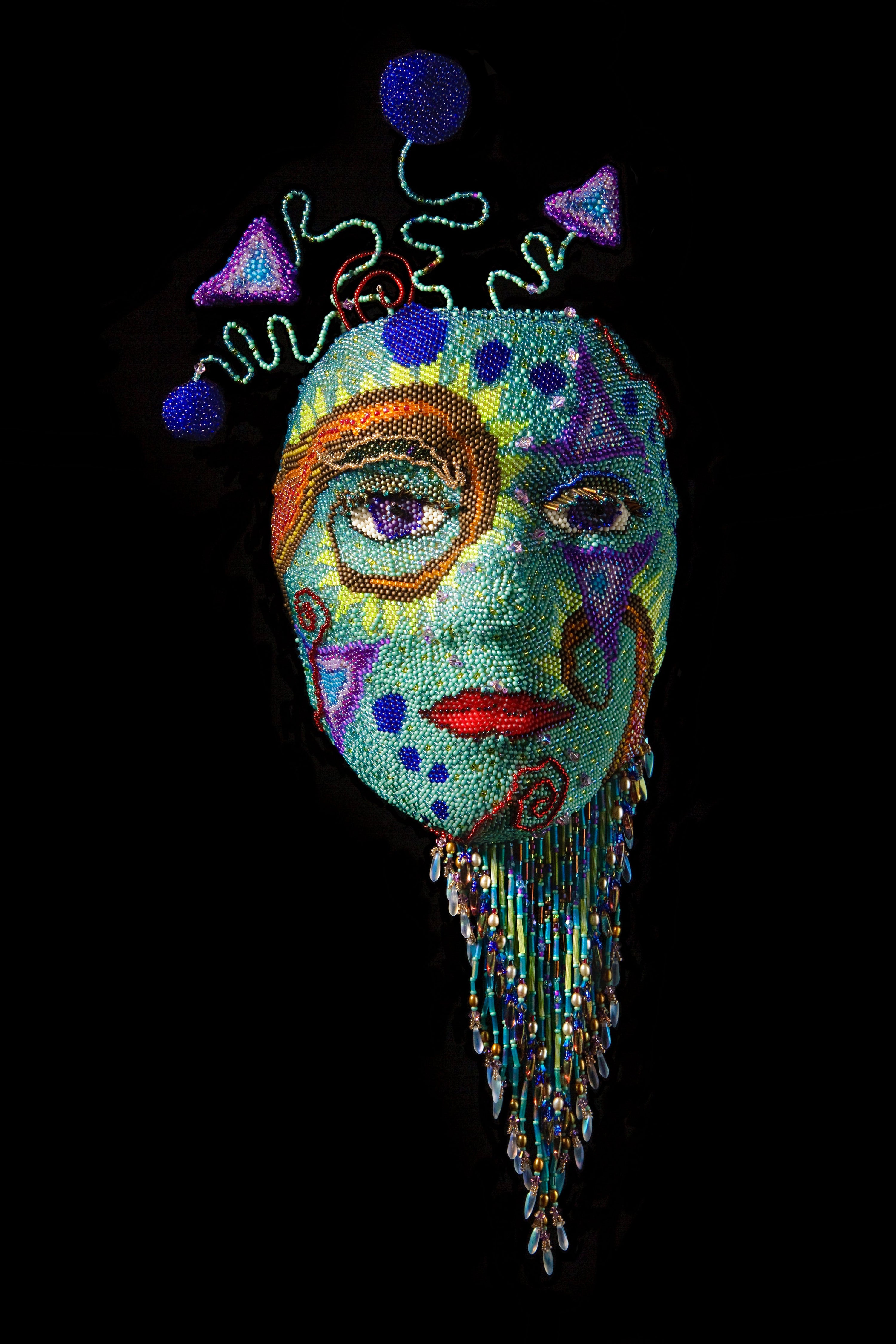 Beadwork mask. Title Delerium -Each beadwork mask is constructed using multiple beadweaving techniques. Each bead goes on one at a time with needle and sturdy thread. Each mask is formed over hand cast armature of a real human face, every one different. 